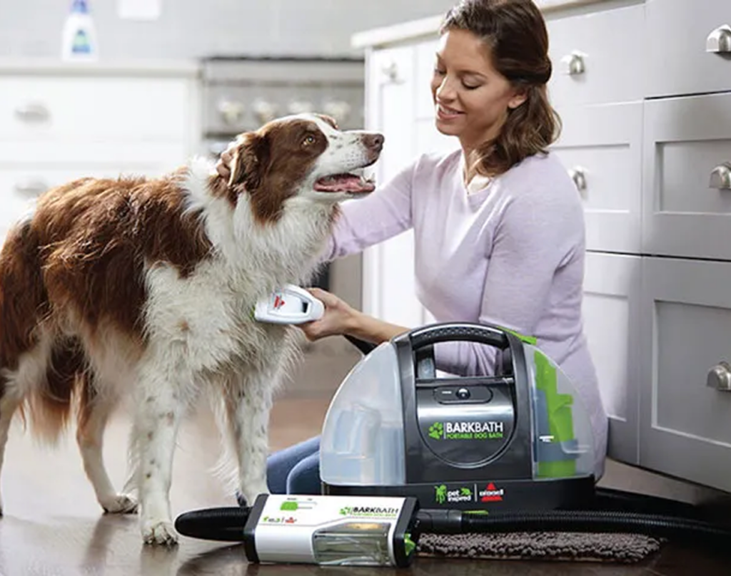 Person washing a dog with the Bissell Bark Bath